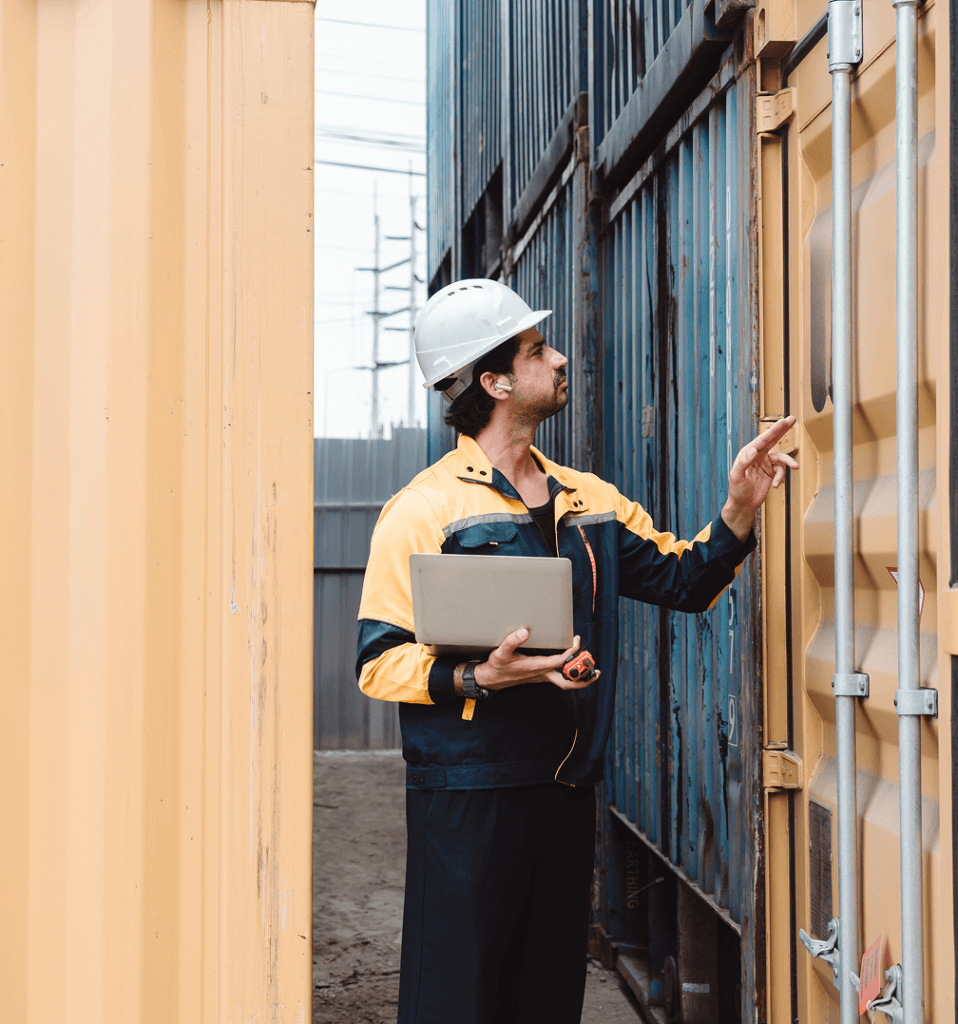 Employé de port analysant des containers de marchandises